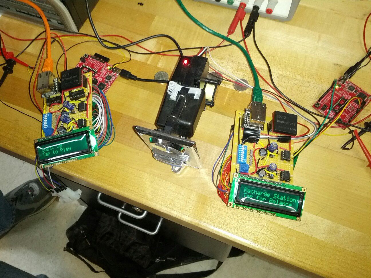 On the right is the SmartPlay recharge station device used by the user to add credits to their account. Users simply tap their RFID tag and insert coins into the slot to add credits. On the left is the SmartPlay arcade game device.